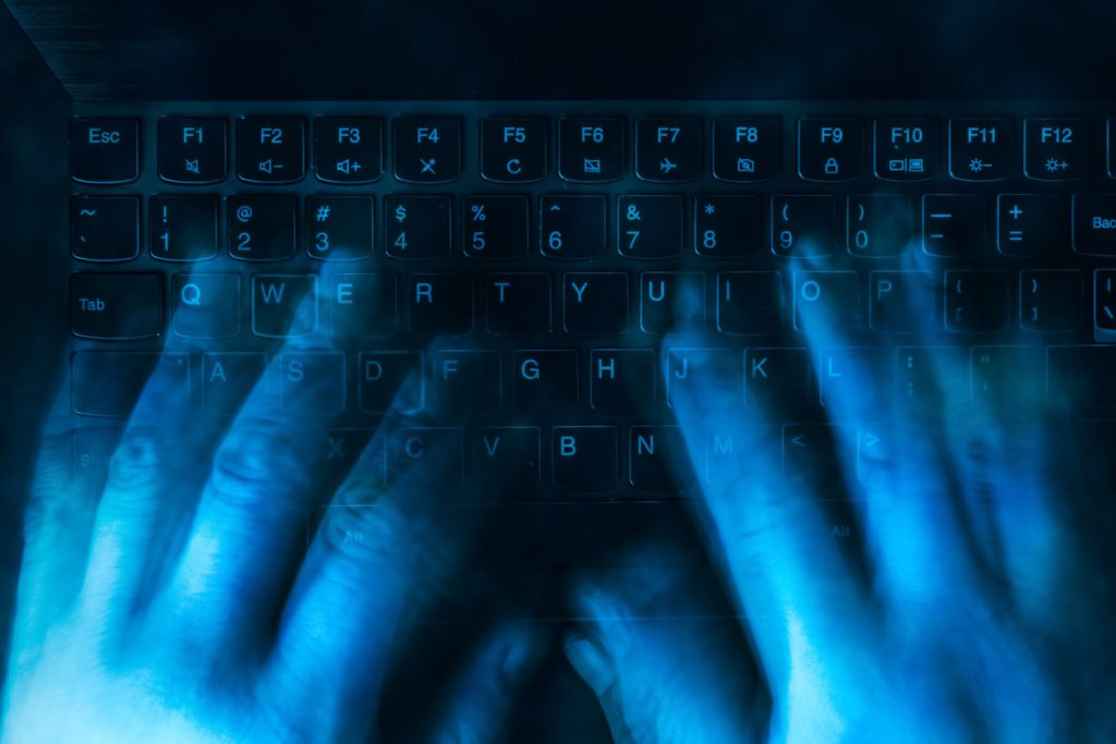 hands are typing on the keyboard in the dark. Blurred